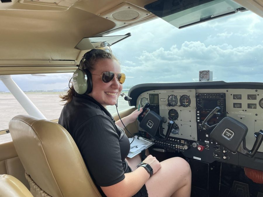 Sarah Miller sitting in the cockpit of a Cessna-172m plane.