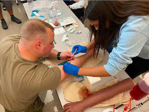 Senior student Kara Grothe inserts a live IV needle to Staff Sgt. Barnett during her second period Health and Sports Medicine class at Central York High School