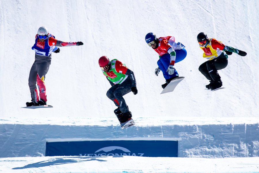Mixed team snowboard cross competitors have the challenge of showing off their cool tricks while racing against their competition.