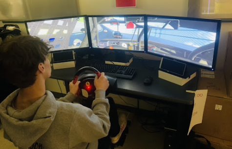 Junior Tyler Anderson is using the driving simulator during iRacing club in the 
Hub.