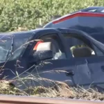 Police and emergency crews responding near an overturned SUV in a canal